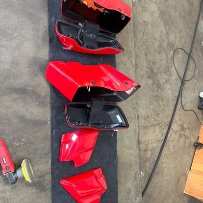 Red motorcycle body panels during detailing in Tony’s shop